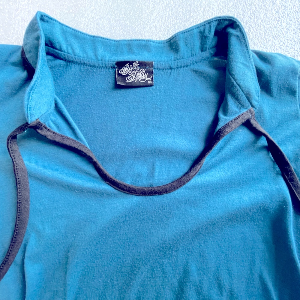 Short sleeve knit top in deep teal with black tie at neck.